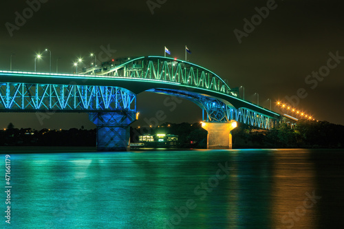 The Auckland Harbour Bridge in Auckland, New Zealand, illuminated with green and blue lighting during Auckland Anniversary celebrations photo