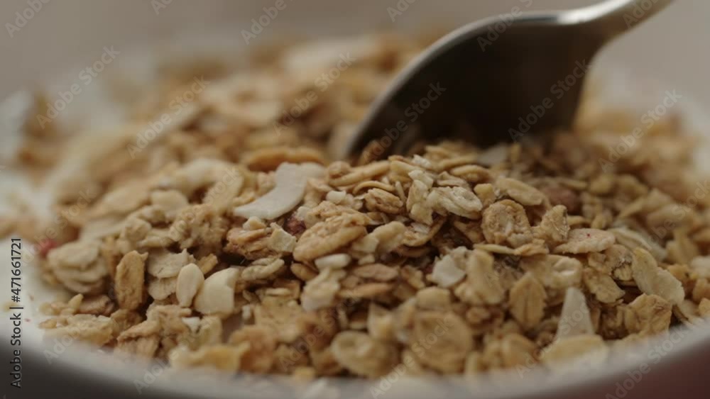 Slow motion macro shot of scooping white yogurt with granola Slow motion macro shot of scooping white yogurt with granola