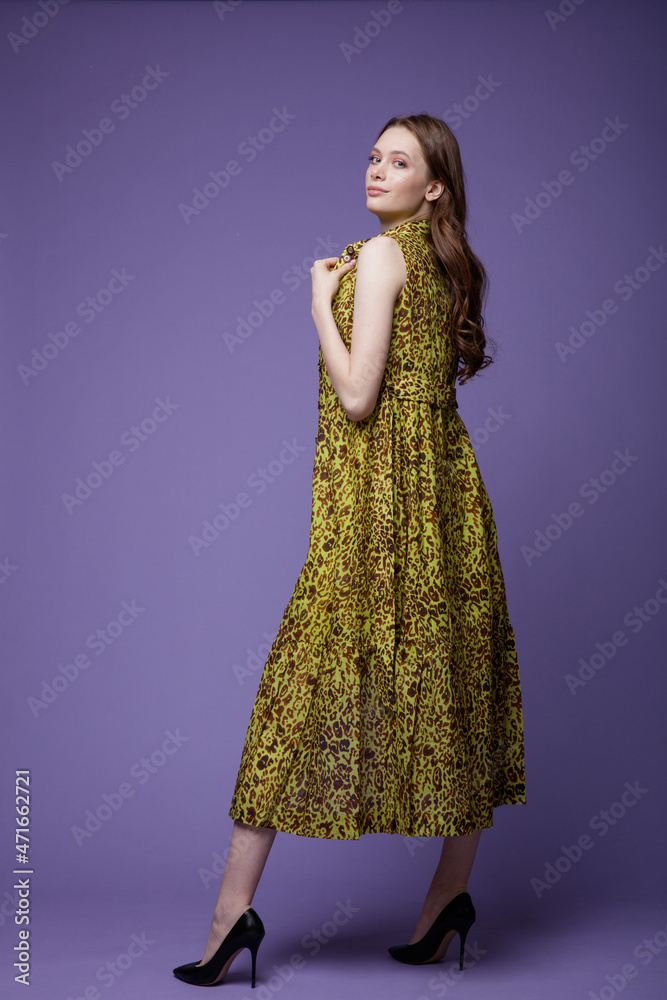 High fashion photo of a beautiful elegant young woman in a pretty robe-dress, white pants, brown top, shoes posing over white, soft gray background. Studio Shot. 