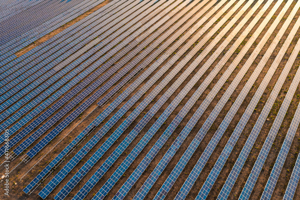 Drone close-up shot of solar panels field, photovoltaic power station illuminated by sunbeams at sunset. Drone close-up shot of solar panels field, photovoltaic power station illuminated by sunbeams at sunset.