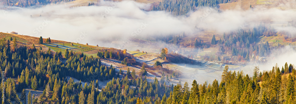 Mountain morning autumn panorama. Colorful fall landscape, foggy sunrise