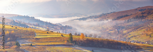Obraz na płótnie Mountain morning autumn panorama. Colorful fall landscape, foggy sunrise in Carpathians. Majestic misty scenery, valley, village w salonie