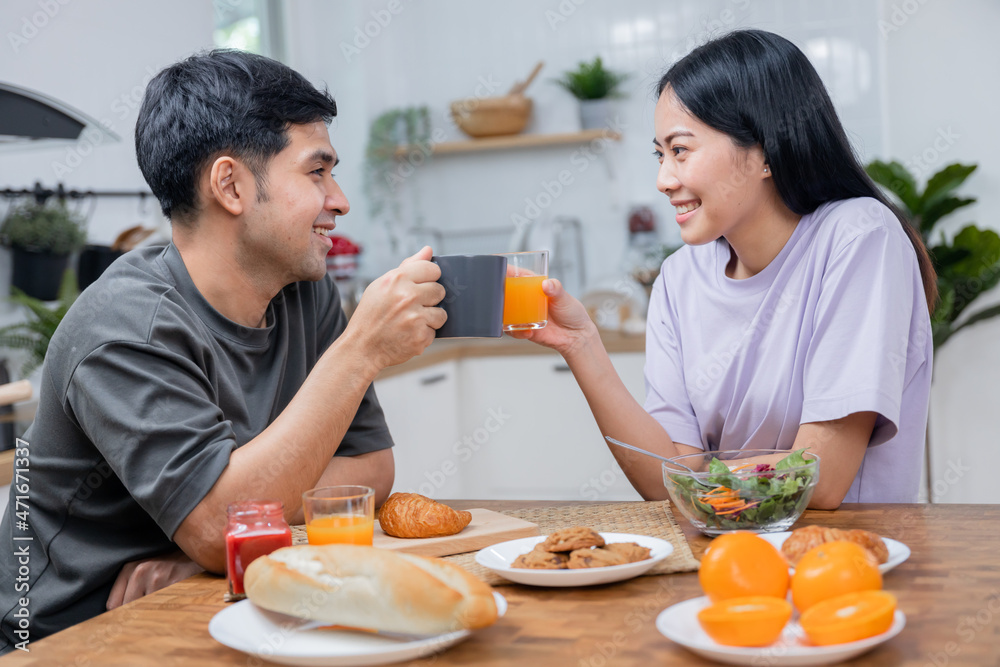 Love Asian couple drinking coffee and orange juice in breakfast time Love Asian couple drinking coffee and orange juice in breakfast time