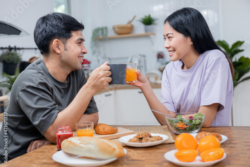 Love Asian couple drinking coffee and orange juice in breakfast time