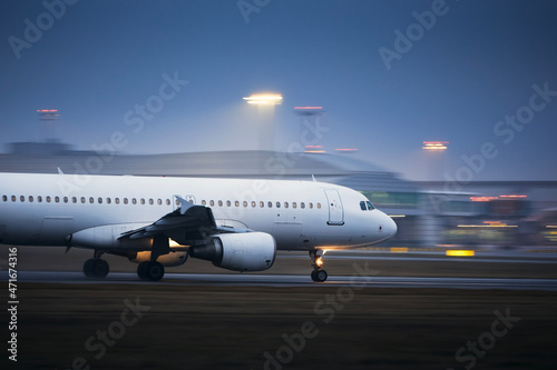 Airplane during take off on airport runway at night. Plane in blurred motion at night..