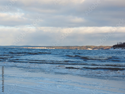 Late autumn on the beach. There are waves on the Kama river. The shore is icy. Russia  Ural  Perm region.