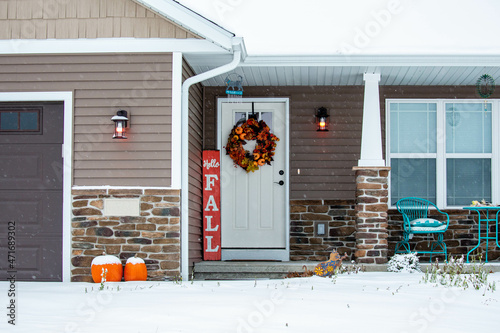 Residential house decorated for autumn with snow on the ground