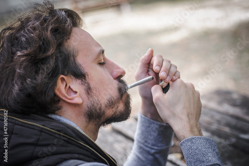 Man lighting up joint marihuana joint cigarette. Closeup detail view