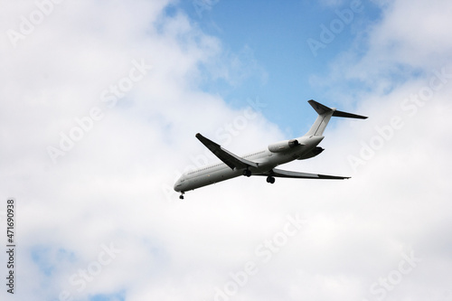 The plane is flying in the sky. Airplane against the background of blue sky and white clouds.