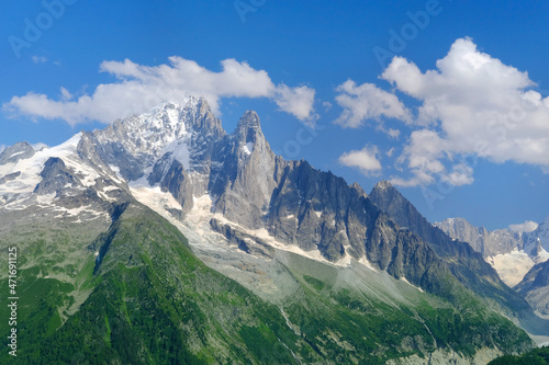 high mountains, rocky cliffs with trees, in the background you can see the French Alps with the snow-capped Mont Blanc, the concept of hiking, rock climbing, active lifestyle, beauty of nature