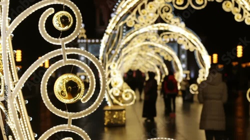 Light Tunnel on VDNH. The long light installation stretched along a sidewalk.Close up of gold ball. Christmas outdoor decor in the Moscow city.People blurred silhouettes
