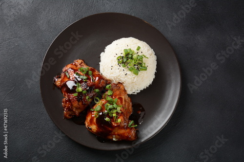 Chicken thighs marinated and cooked in adobo sauce. National filipino dish. Adobo with rice close-up on a plate. photo