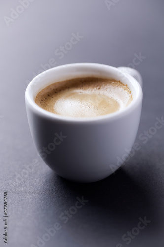 Cup of coffee on dark paper background. Close up. 