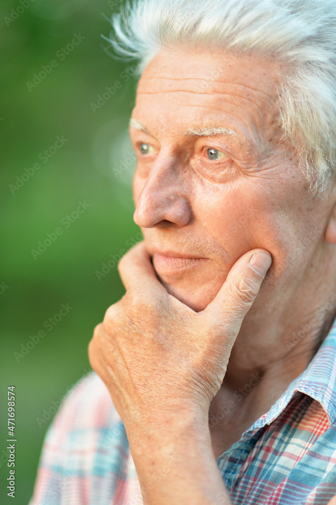 portrait of thinking senior man in park portrait of thinking senior man in park