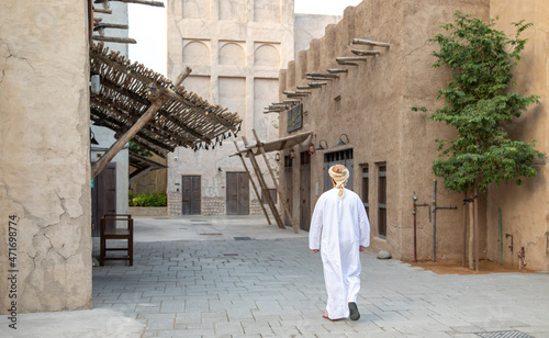 Arab man walking in the alleys of al seef district in Dubai