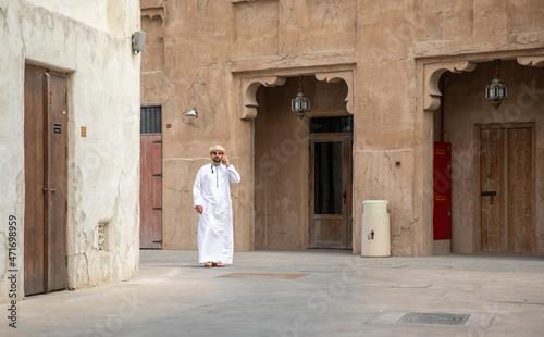 Arab Man walking in al seef district in dubai and talking in the phone © SELIMBT