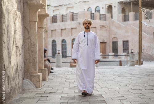 Arab man walking in the alleys of al seef district in Dubai