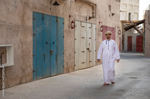 Arab man walking in the alleys of al seef district in Dubai