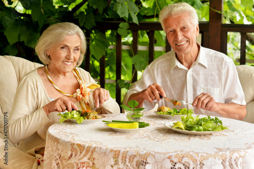 Portrait of happy senior couple having diner and posing on the veranda