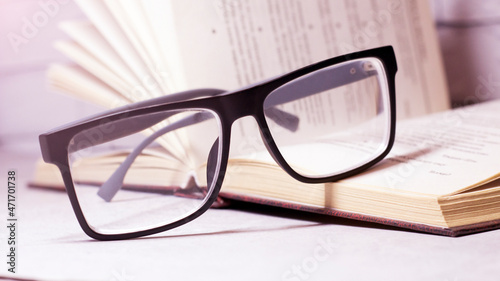 Black-rimmed eyeglasses and an open book