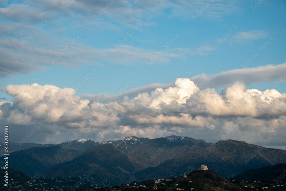 Huge, white clouds over the mountains. Panorama of mountains, hills of the city of Batumi from a bird's eye view. Day. Georgia. Sunny