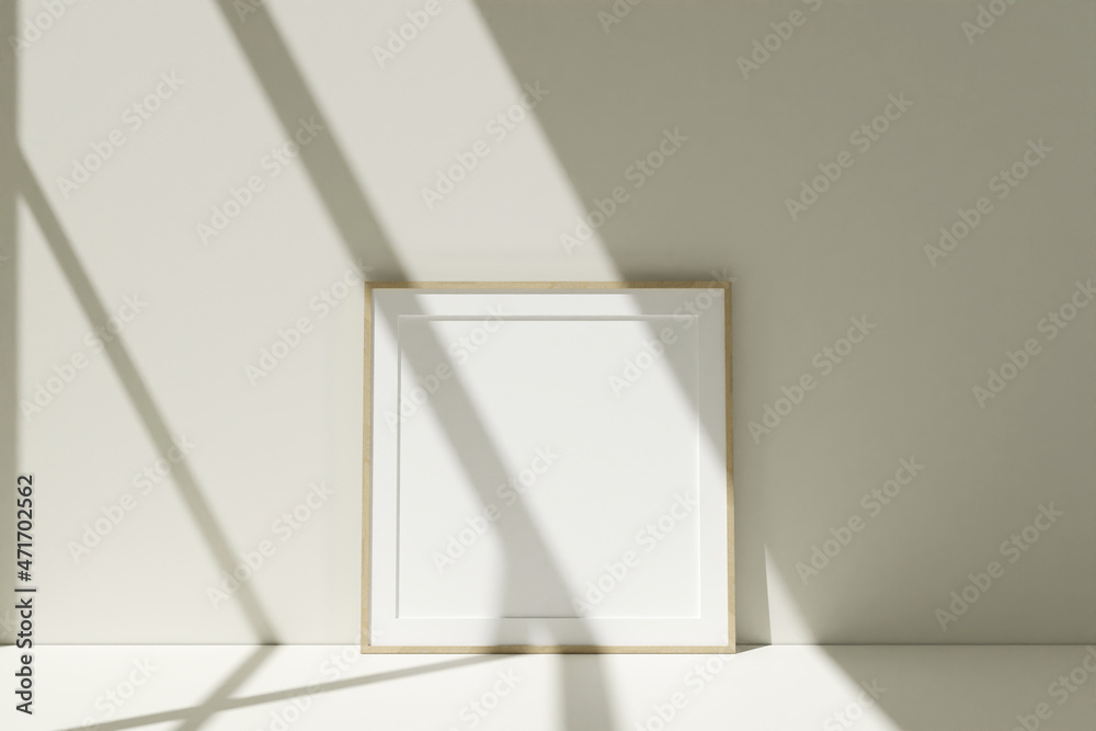Square wooden photo frames mockup on the floor leaning against the room wall with shadow Square wooden photo frames mockup on the floor leaning against the room wall with shadow