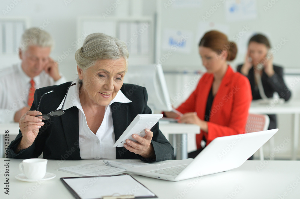 Business woman with a calculator in office Business woman with a calculator in office