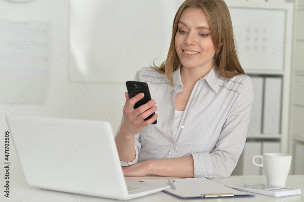 young business woman with laptop holding smartphone young business woman with laptop holding smartphone