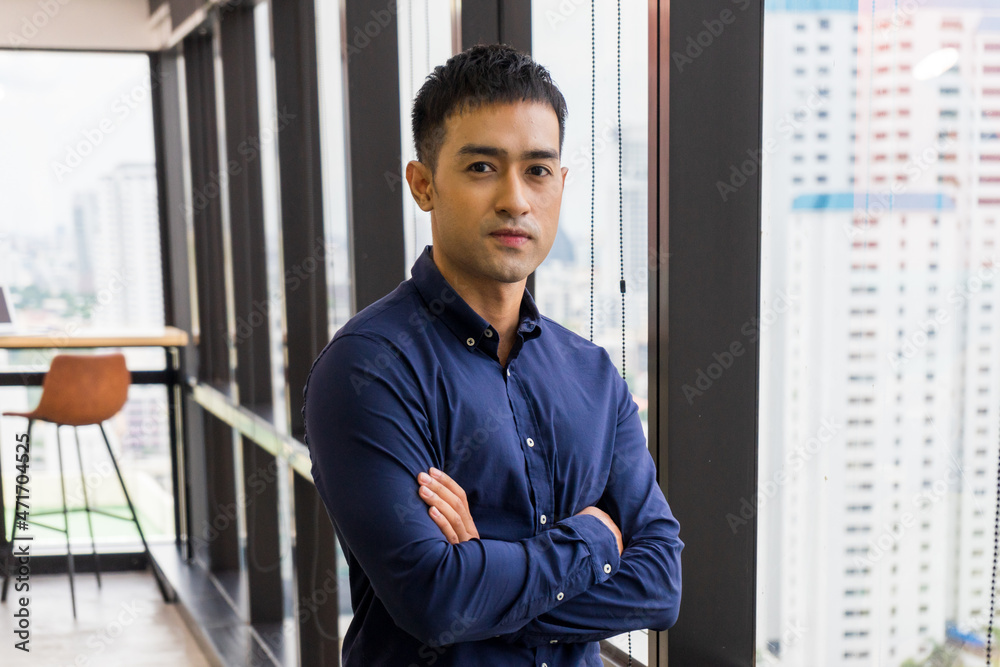 Young businessman executive in suit looking at camera on window with city building background. Young businessman executive in suit looking at camera on window with city building background.
