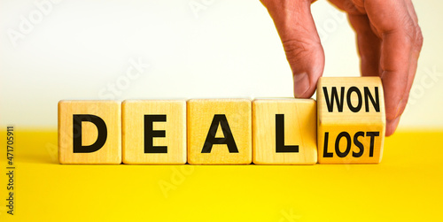 Deal lost or won symbol. Businessman turns a wooden cube and changes words deal lost to deal won. Beautiful yellow table, white background, copy space. Business and deal lost or won concept.