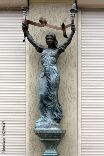 Bronze sculpture of woman with torches outdoor photo