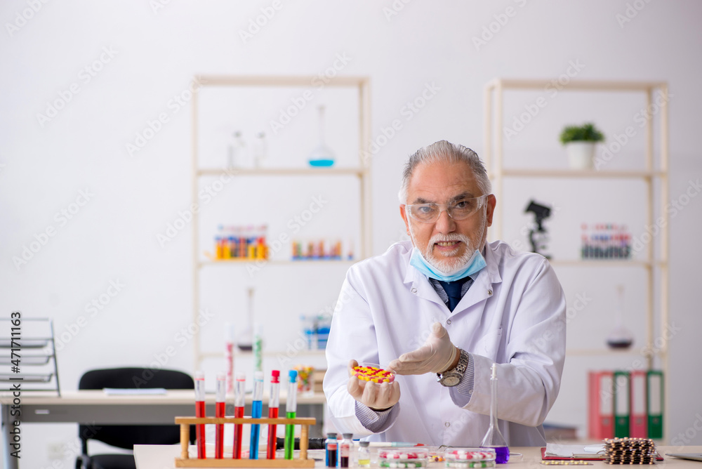 Old male chemist in drug synthesis concept Old male chemist in drug synthesis concept