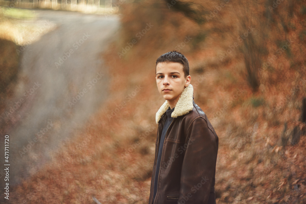 young teenager stands in the woods in late November young teenager stands in the woods in late November