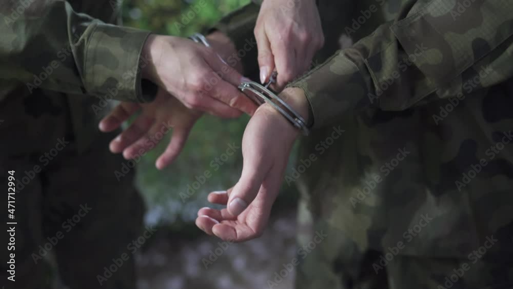 Military officer unshackles prisoner from handcuffs. He regains his freedom. Military officer unshackles prisoner from handcuffs. He regains his freedom.