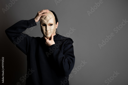anonymous stranger, a woman in a black hoodie covers her face with a mask, secrecy and privacy