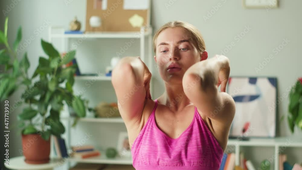 Sportswoman blogger showing exercises for shoulders. Young blonde woman training in living room. Professional fitness trainer, home gym concept. Remote workouts during coronavirus quarantine. Sportswoman blogger showing exercises for shoulders. Young blonde woman training in living room. Professional fitness trainer, home gym concept. Remote workouts during coronavirus quarantine.