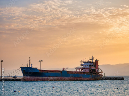 Scenic view at sunset with a docked old rusted ship in the port of Aqaba city, Jordan.