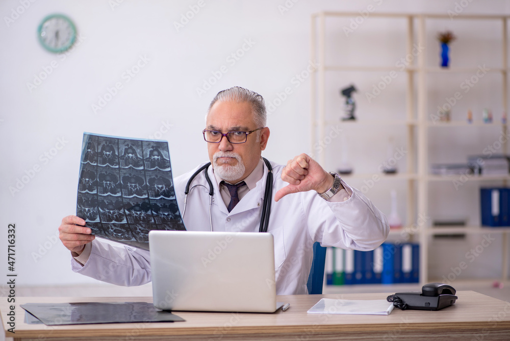 Old male doctor radiologist working at the hospital Old male doctor radiologist working at the hospital