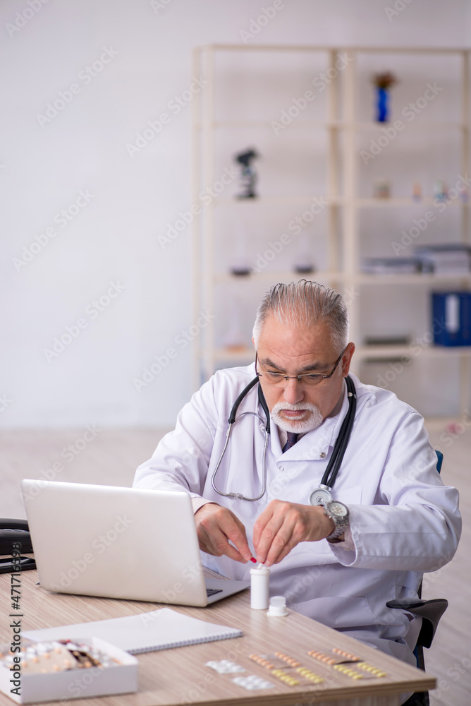 Old male doctor working at the hospital