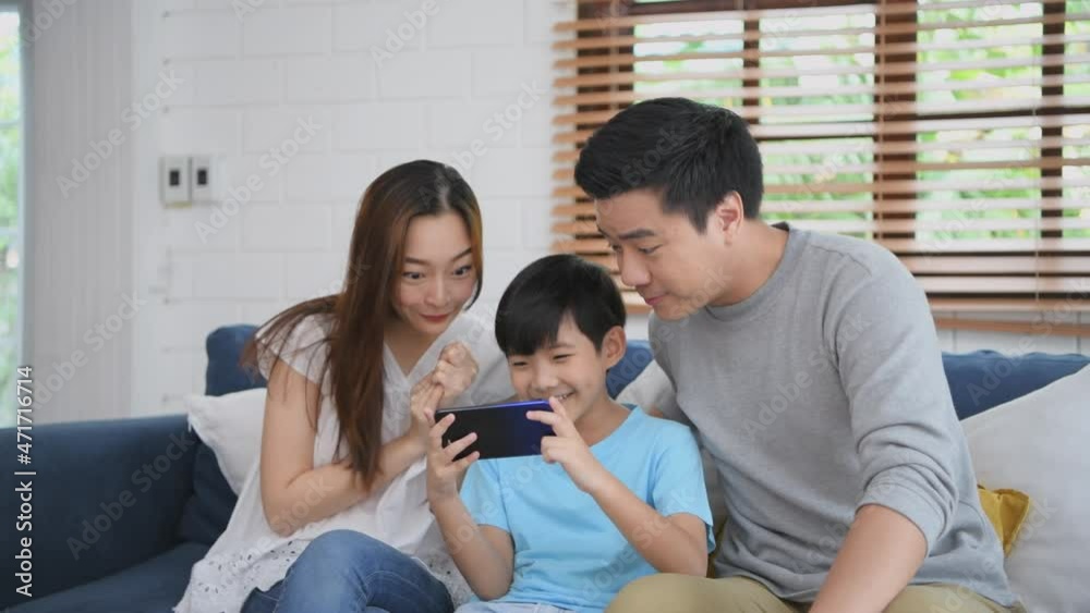 Family concept of 4k Resolution. Parents encourage their son to play games in the living room. Activities to do together during the holidays. Family concept of 4k Resolution. Parents encourage their son to play games in the living room. Activities to do together during the holidays.