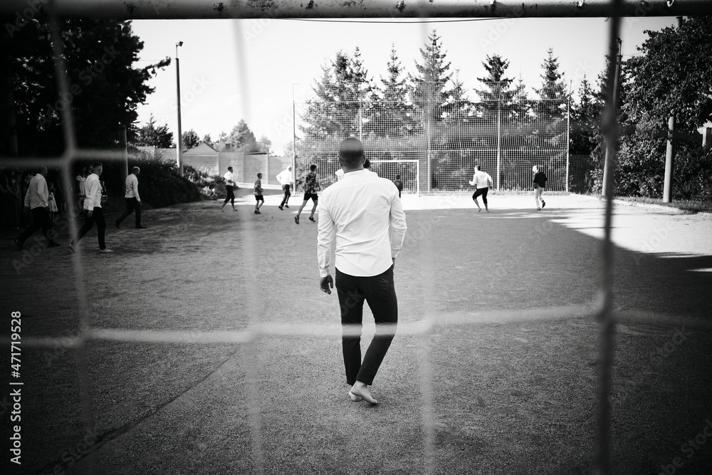 Photo taken at a wedding where the wedding guests are playing football. Taken behind the goal.
