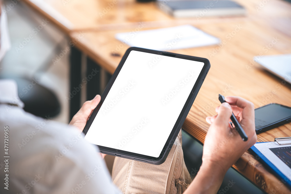 hand image of a male freelancer holding a blank screen tablet in his modern workplace