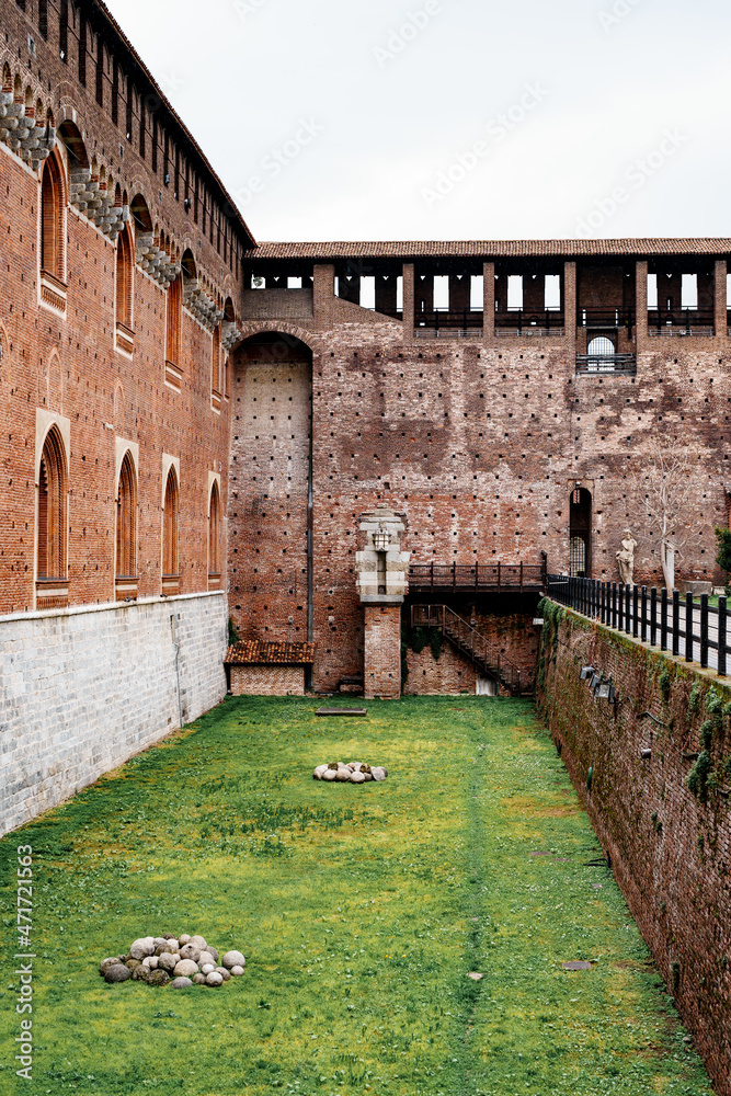 Green lawn near the wall of the Castello Sforzesco. Milan, Italy
