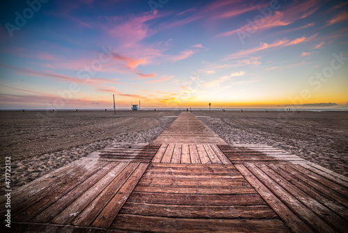 Fototapeta Naklejka Na Ścianę i Meble -  Wooden boardwalk on the sand in Santa Monica beach at sunset