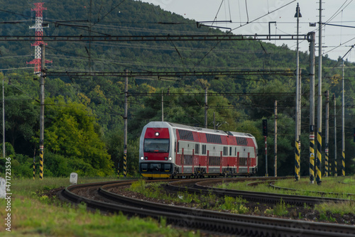 Passenger train with electric red unit in summer evening photo