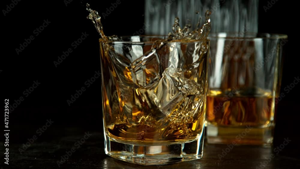 Super slow motion of falling ice cube into whiskey drink, camera motion. Filmed on high speed cinema camera, 1000 fps. Super slow motion of falling ice cube into whiskey drink, camera motion. Filmed on high speed cinema camera, 1000 fps.