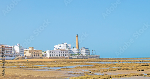 Fishing corrals at low tide on the beach with the Chipiona lighthouse in the background, Cadiz, Andalusia, Spain. Andalusian village tradition photo