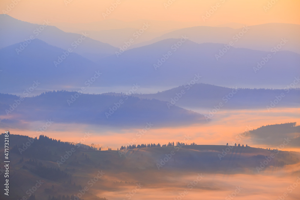 mountain ridge silhouette in blue mist, early morning mountain valley scene