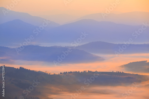 mountain ridge silhouette in blue mist  early morning mountain valley scene