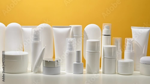 jar, bottle and empty white plastic tubes for cosmetics on a yellow background. Packaging for cream, gel, serum, advertising and product promotion, mock up